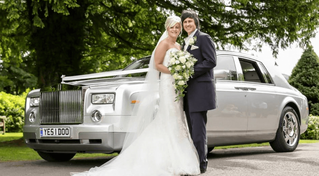 Happy couple having photoshoot next to Rolls Royce vintage car