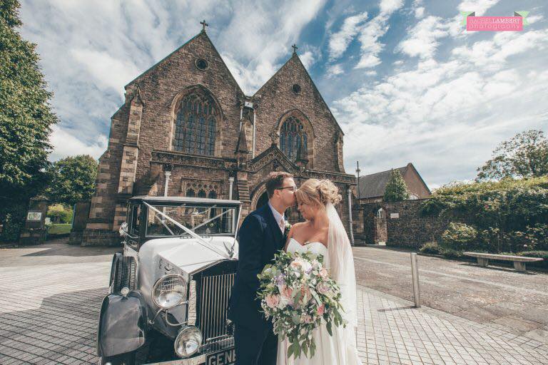 bride and groom outside newport wedding venue with large flower arrangements