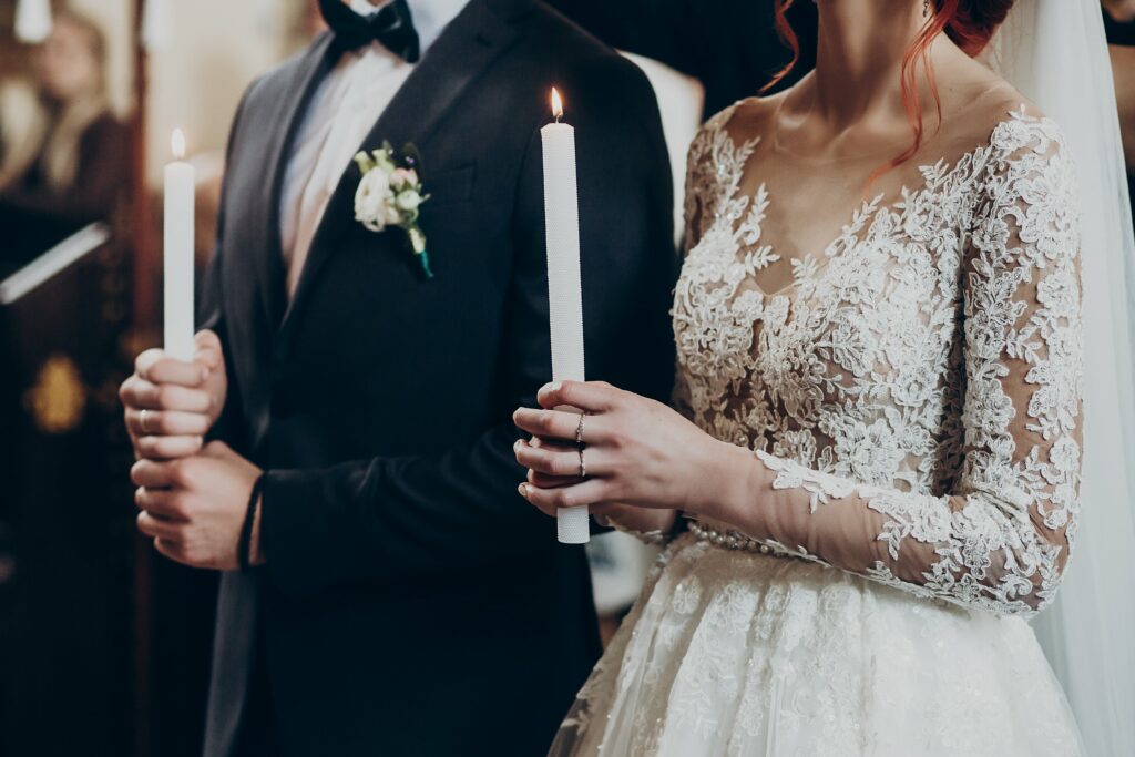 wedding couple in ceremony within church holding candles
